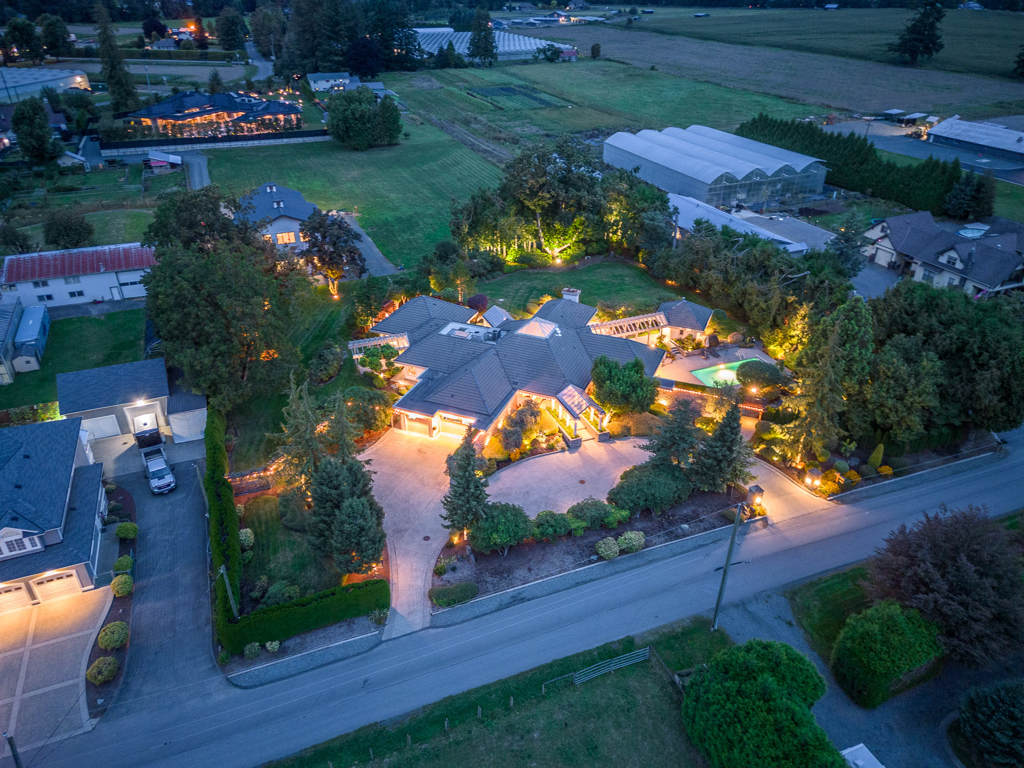 Panoramic aerial drone photography of Chilliwack, BC, showcasing the lush valley floor, Fraser River, and the majestic peaks of the Cheam Mountain Range.